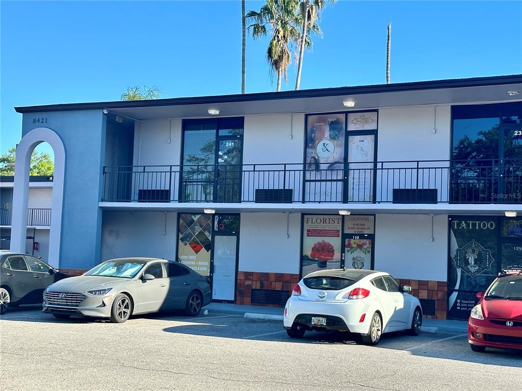A two-story commercial building with multiple storefronts and a parking lot in front — 8421 S ORANGE BLOSSOM TRAIL UNIT 443, ORLANDO, FL