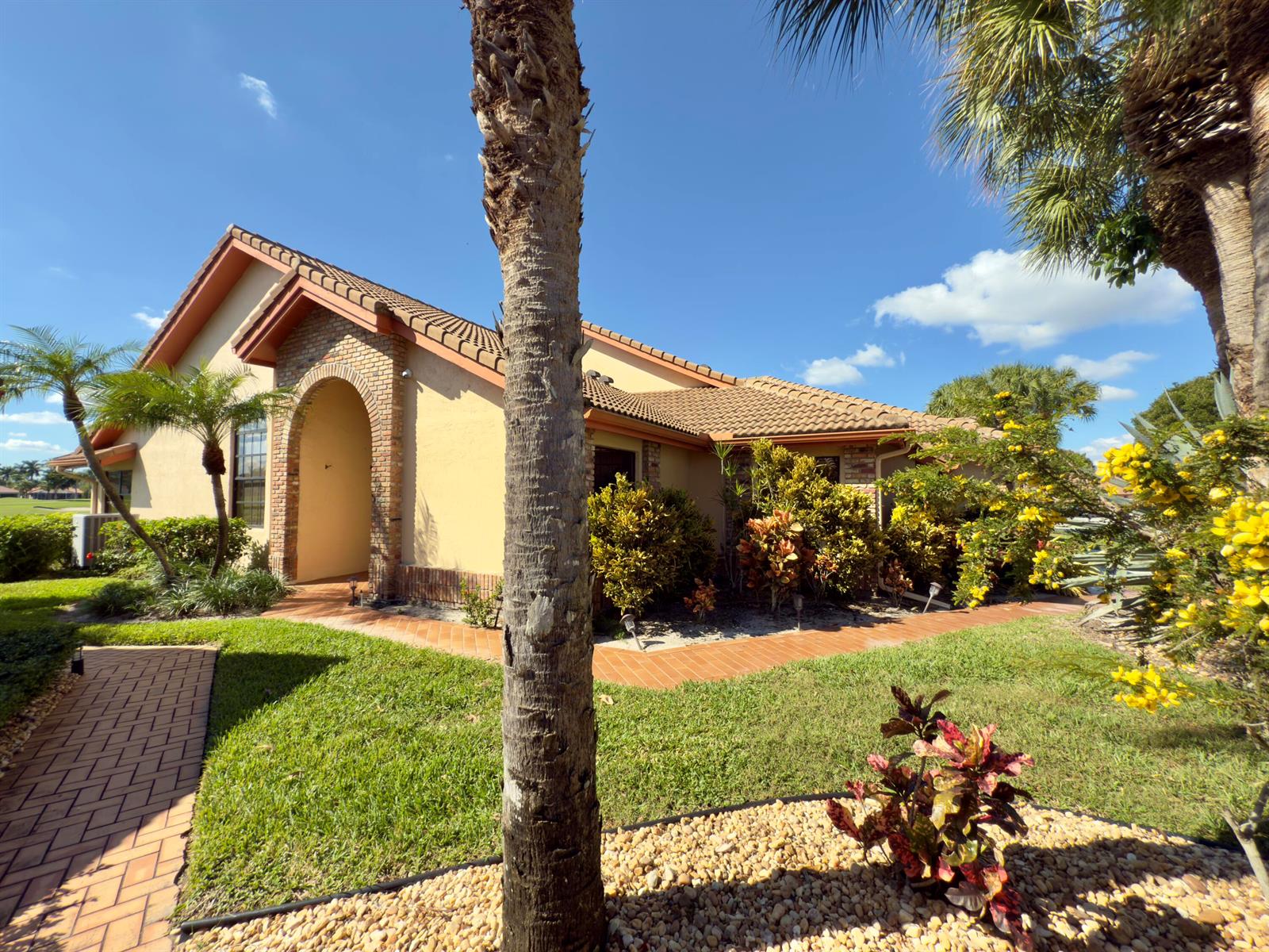 A tan stucco house with a brick arched entryway and a tiled roof — 8491 Heather Place, Boynton Beach FL 33472, BOYNTON BEACH, FL