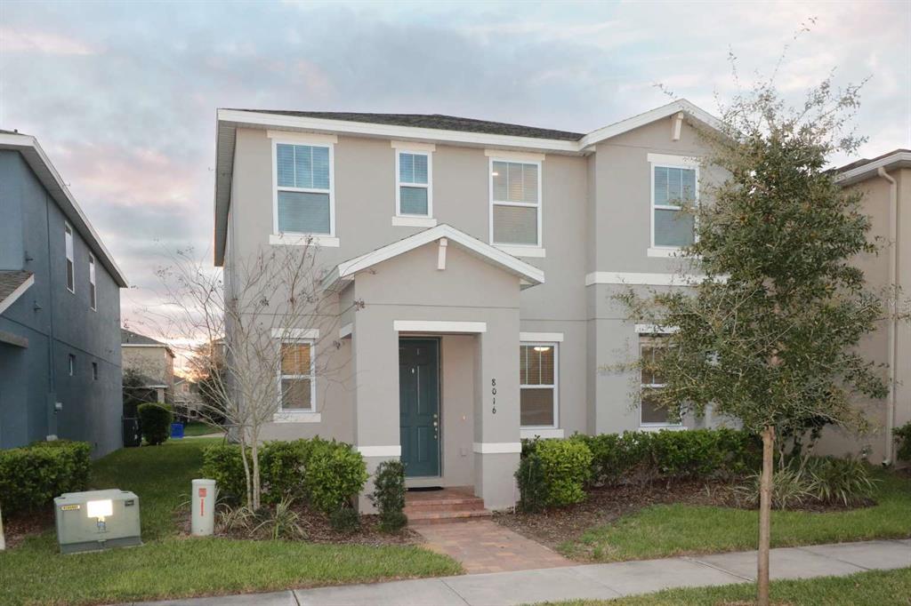 A two-story house with a gray exterior, a covered entryway, and a paved walkway — 8016 SWEET ORANGE AVENUE, WINTER GARDEN, FL