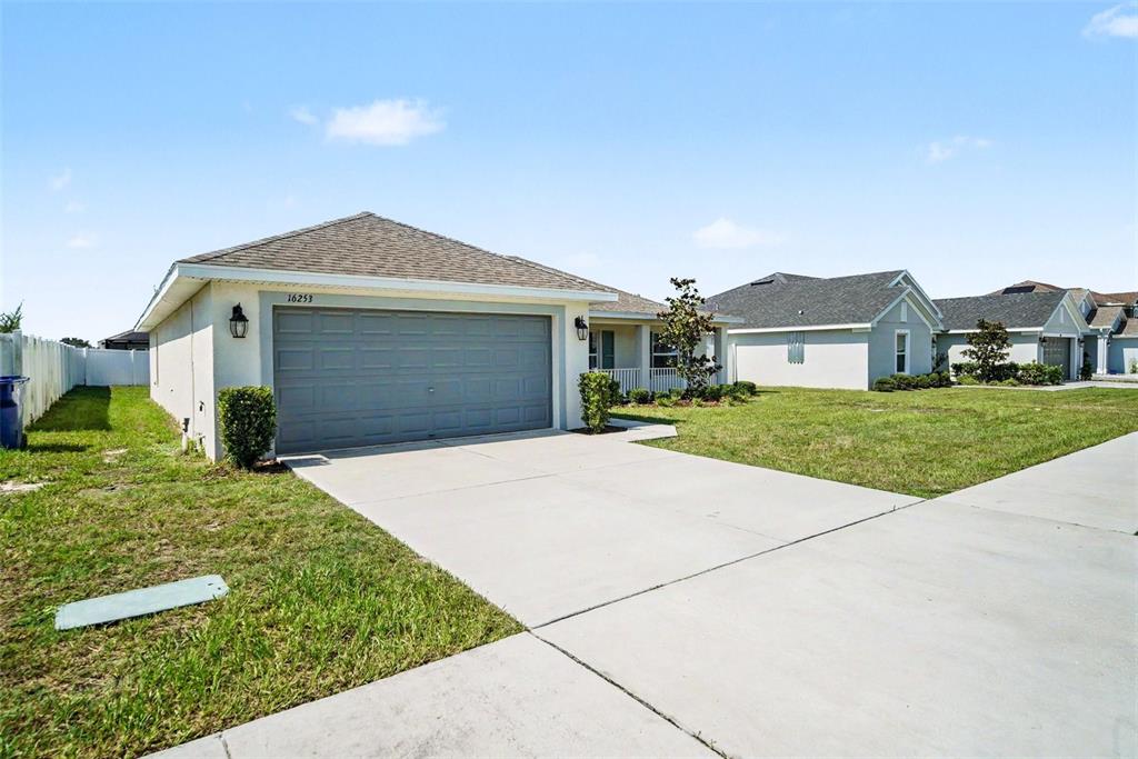 A single-story house with a gray garage door and a concrete driveway — 16253 VINE CLIFF AVENUE, HUDSON, FL