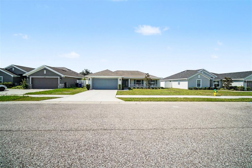 A single-story suburban house with a gray garage and a front porch — 16253 VINE CLIFF AVENUE, HUDSON, FL