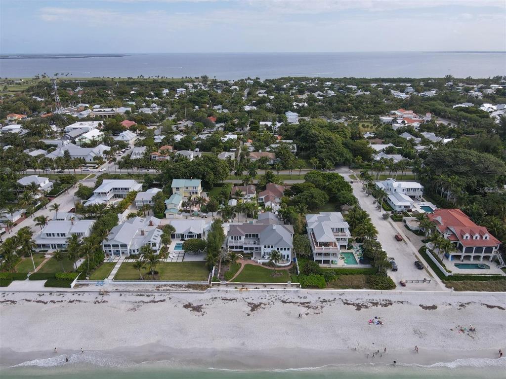 An aerial view shows beachfront houses with pools along a sandy shore and ocean — 241 GILCHRIST AVENUE UNIT C, BOCA GRANDE, FL
