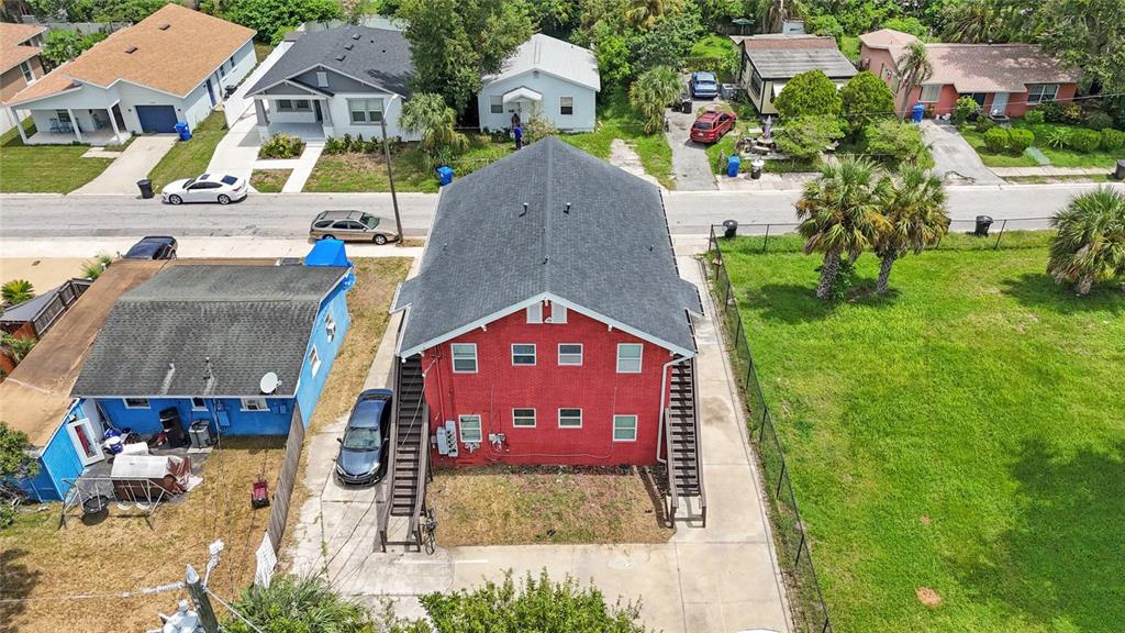 An aerial view shows a red brick apartment building with exterior staircases and a parking area — 1761 19TH STREET S, ST PETERSBURG, FL