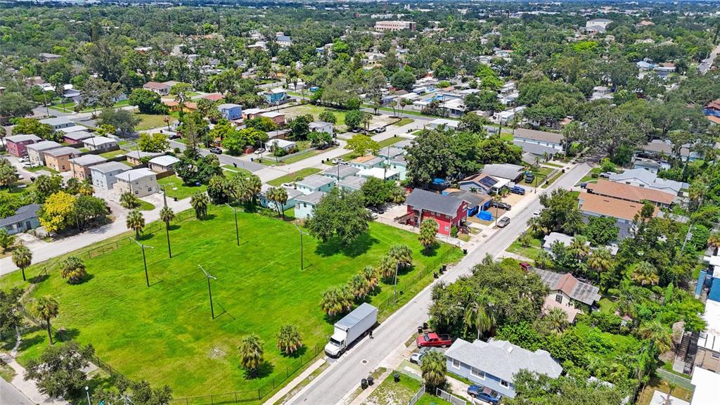 An aerial view shows a large grassy lot next to a street with houses — 1761 19TH STREET S, ST PETERSBURG, FL