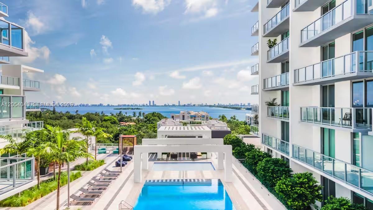 An elevated view of a swimming pool terrace between two modern apartment buildings overlooking water — 3900 Biscayne Blvd # 216, Miami FL 33137, MIAMI, FL