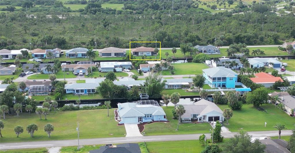 An aerial view shows a residential neighborhood with houses, canals, and a highlighted single-story home — 3103 RIVERSIDE DRIVE, PUNTA GORDA, FL
