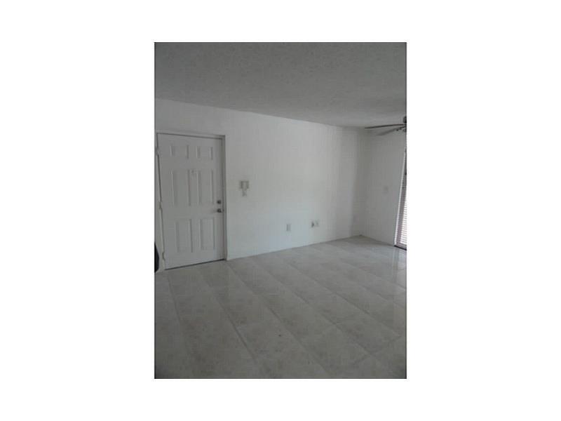 An empty room with white walls, a white front door, and light-colored tiled flooring — 12166 Saint Andrews Place # 111, Miramar FL 33025, MIRAMAR, FL