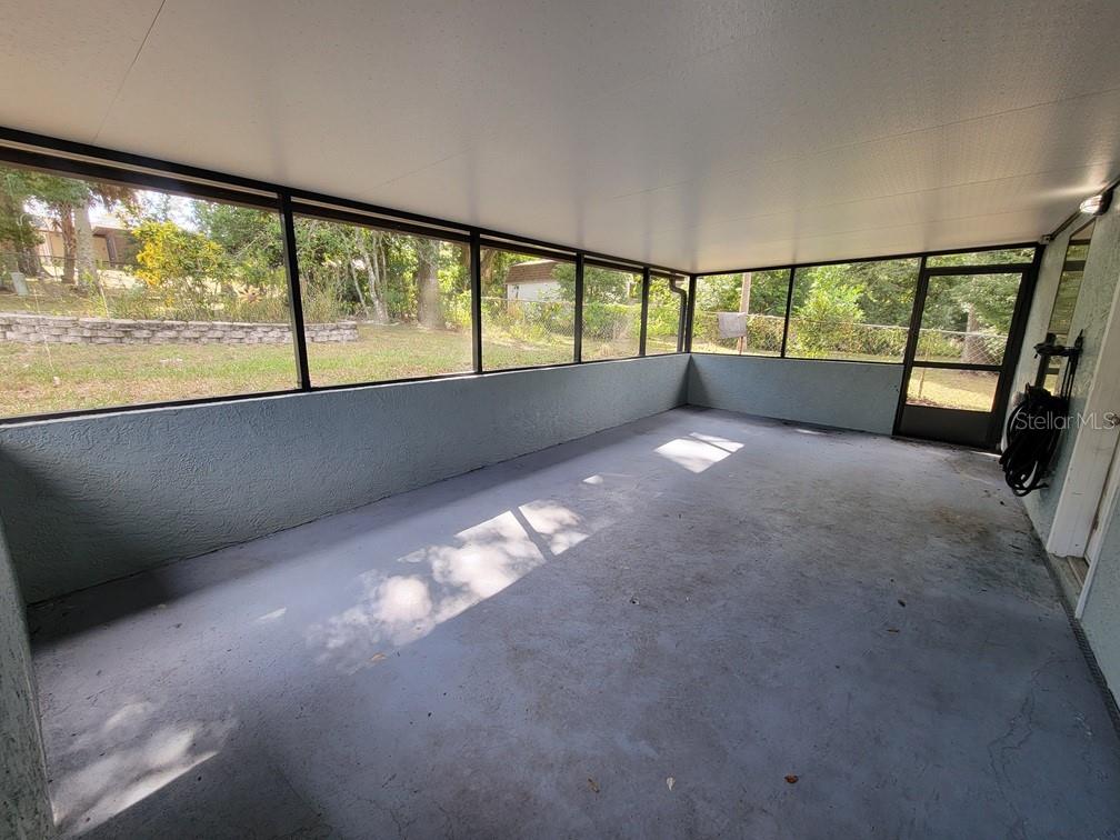A screened-in porch with a concrete floor, light blue walls, and a white ceiling — 11633 FOX RUN, PORT RICHEY, FL