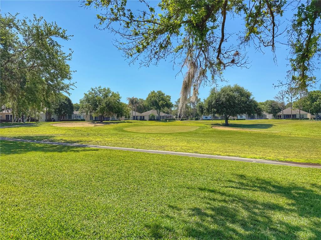 A view of a golf course green with sand bunkers surrounded by residential homes — 3445 CAPLAND AVENUE, CLERMONT, FL