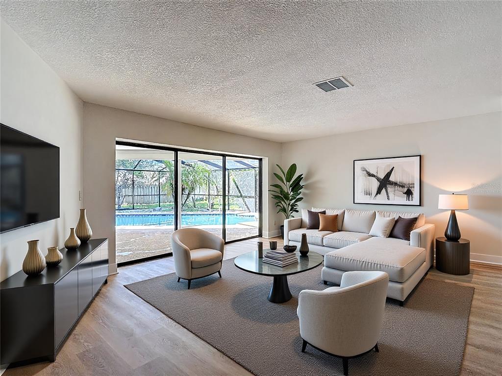 A living room features a sectional sofa, two armchairs, a coffee table, and pool views — 4072 BELMOOR DRIVE, PALM HARBOR, FL