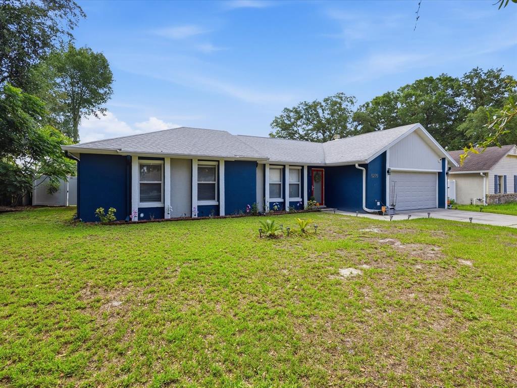 A blue, single-story house with a gray shingled roof and an attached two-car garage — 5275 SIGNAL HILL ROAD, ORLANDO, FL