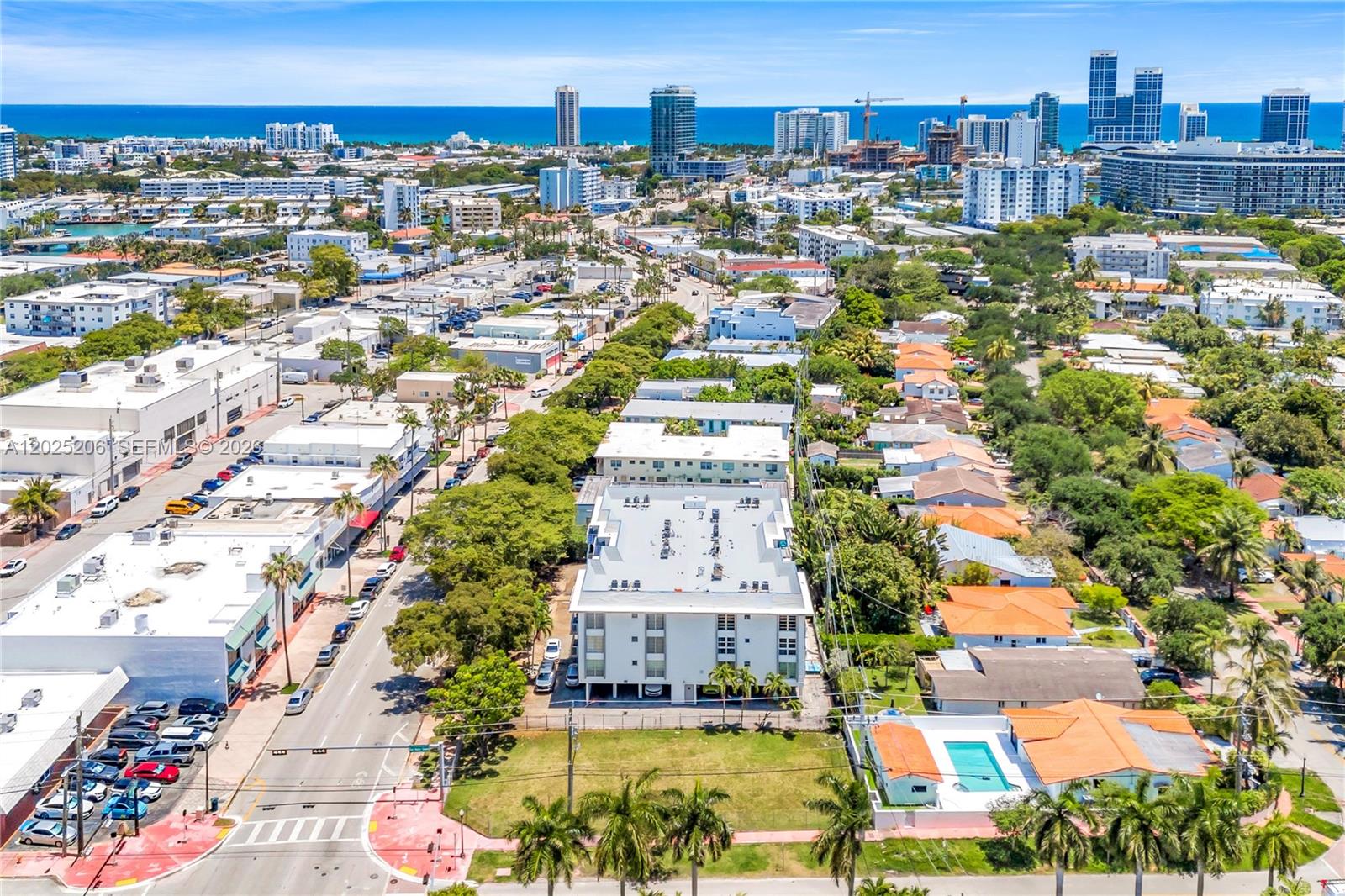 An aerial view shows a multi-story apartment building surrounded by suburban homes and city streets — 1240 71st St, Miami Beach FL 33141, MIAMI BEACH, FL