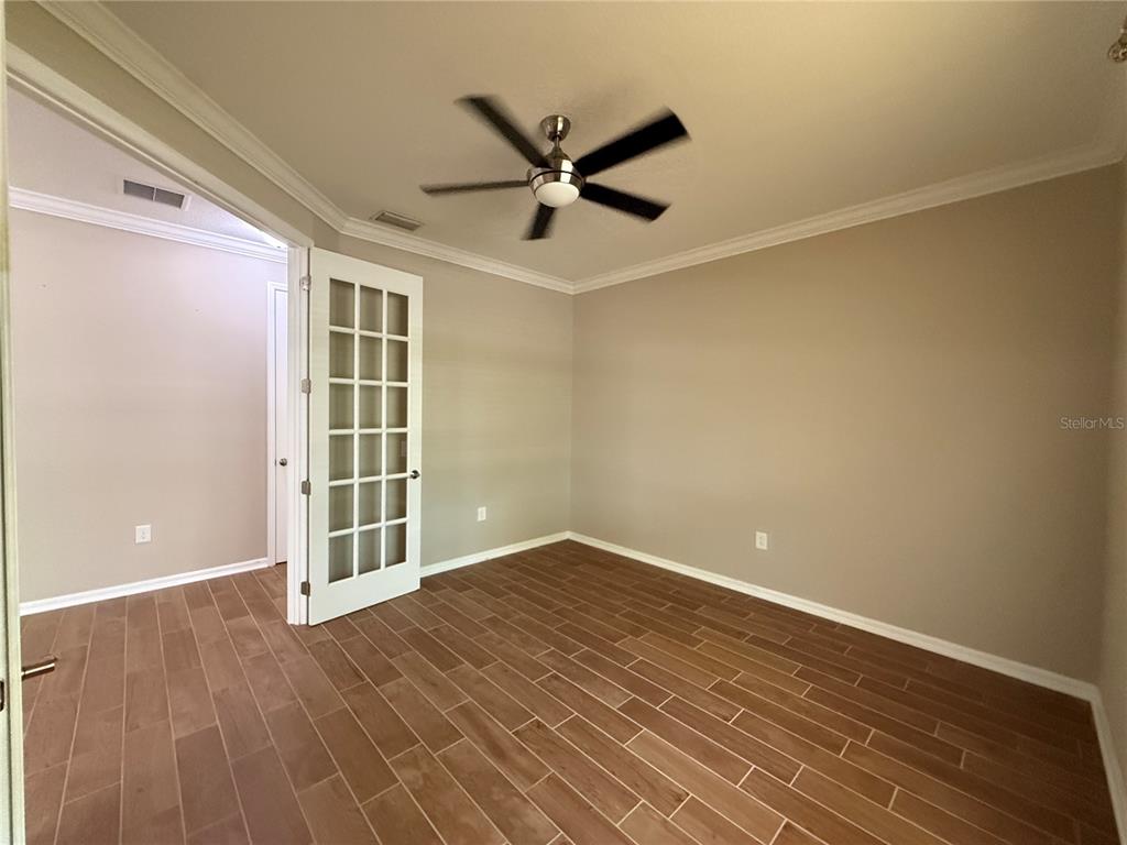 An empty room with light-colored walls, a ceiling fan, and wood-look tile flooring — 12200 RANGELAND BOULEVARD, ODESSA, FL
