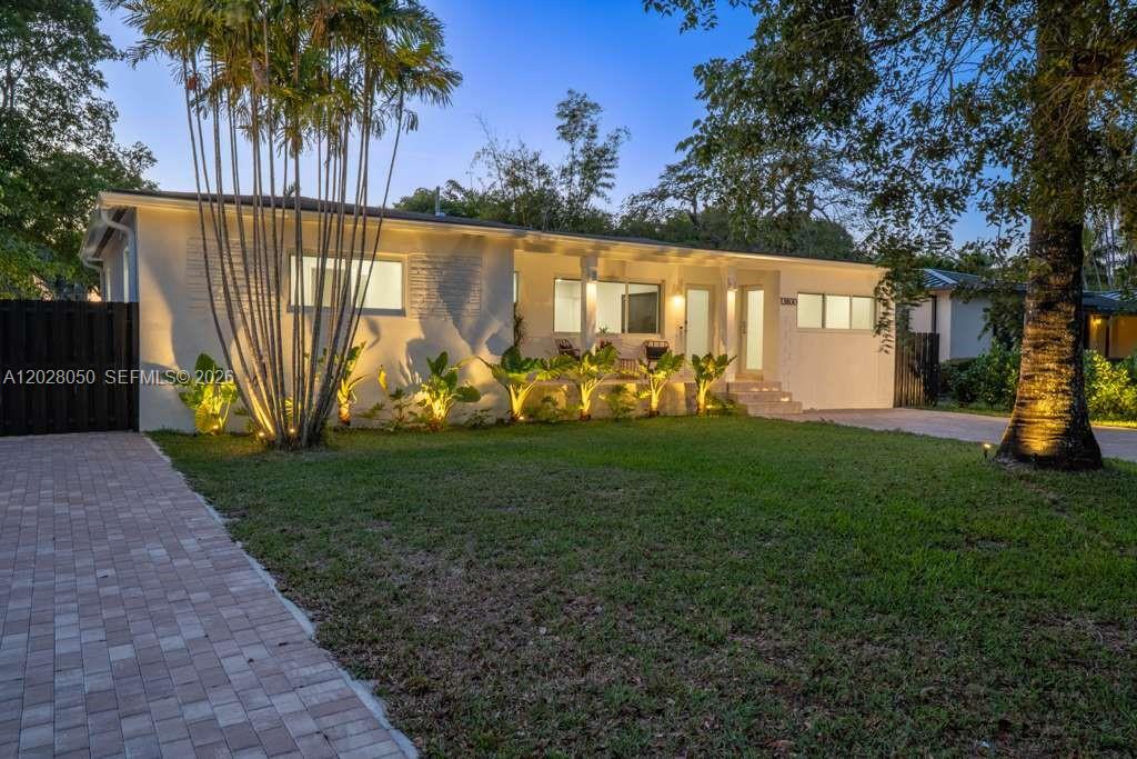 The exterior of a single-story house features a paved driveway, palm trees, and landscaping — 13800 NE 1st Ave, Miami FL 33161, MIAMI, FL
