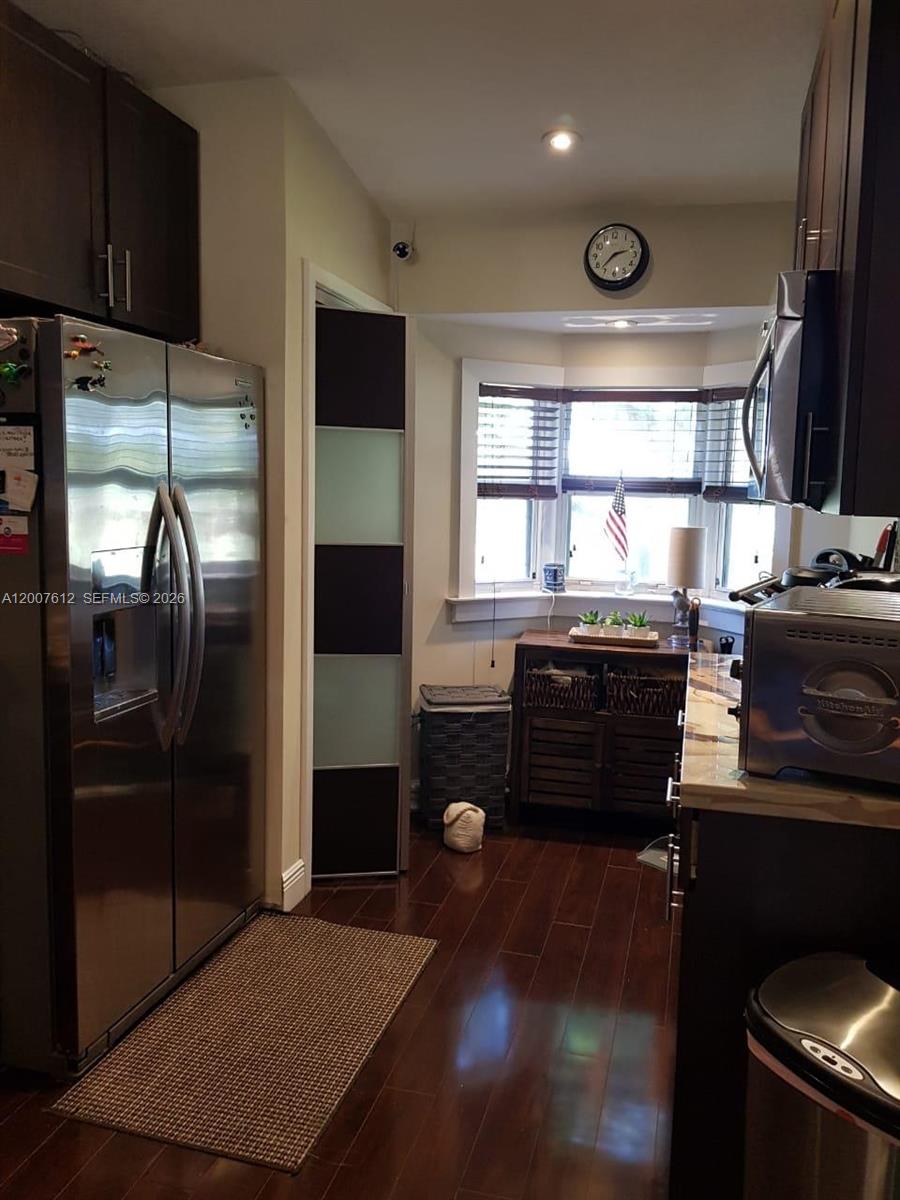 A kitchen features dark wood cabinets, stainless steel appliances, and a bay window with blinds — 930 NE 33rd Ter # 202, Homestead FL 33033, HOMESTEAD, FL