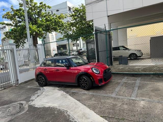 A red Mini Cooper is parked in a concrete lot next to a fenced building — 711 UNION STREET UNIT 8 N, SAN JUAN, PR