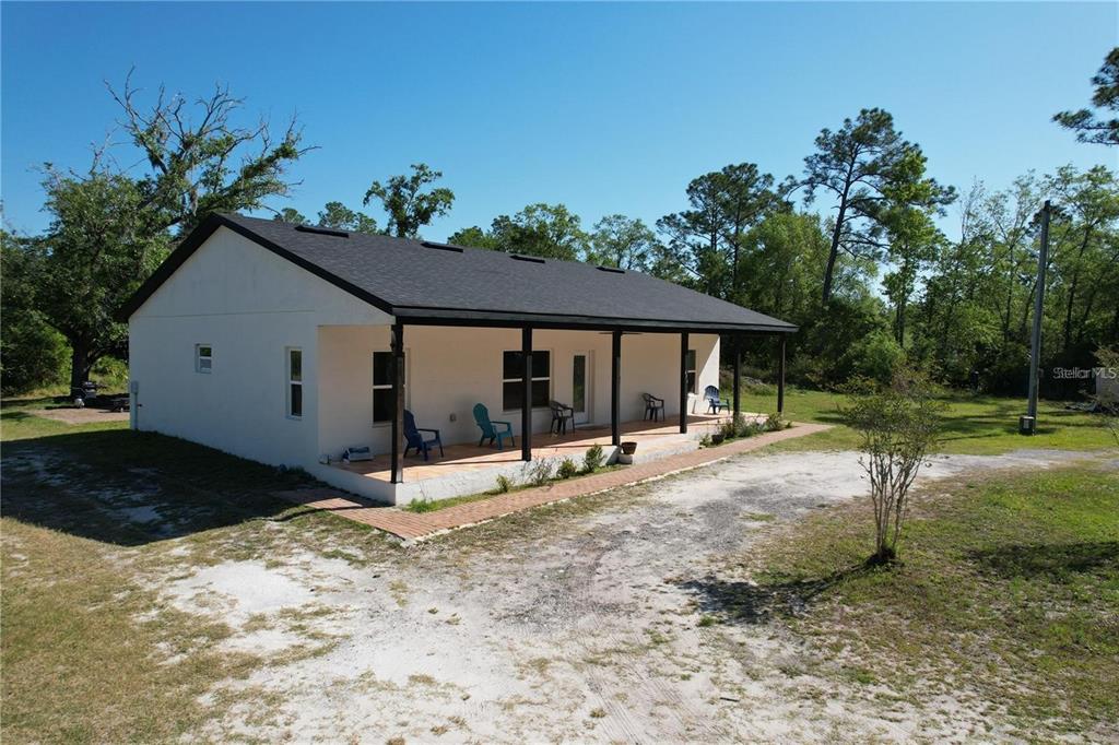 A white, single-story house with a dark roof and a covered front porch sits outdoors — 456 BARON ROAD, ORLANDO, FL