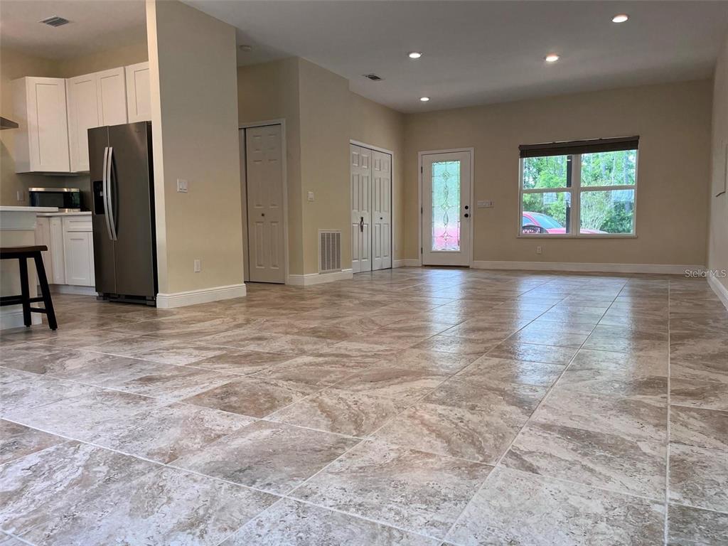 A kitchen with stainless steel appliances and a large open living area with tiled floors — 456 BARON ROAD, ORLANDO, FL