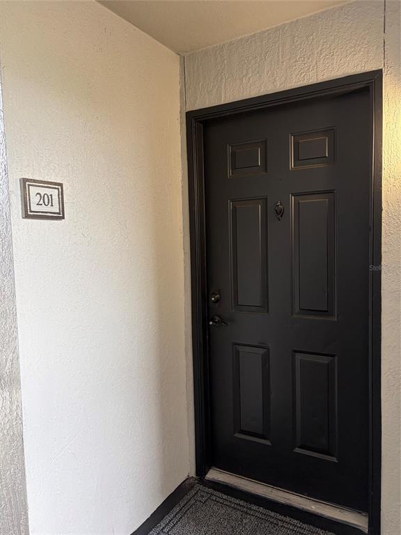 A black front door with a door knocker is labeled with the number 201 — 7511 SEURAT STREET UNIT 10201, ORLANDO, FL
