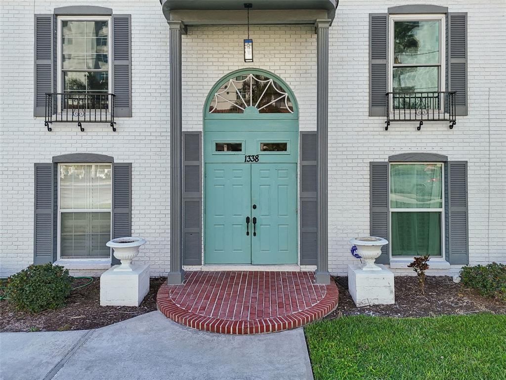 A white brick building features a teal double door entrance with a fanlight window — 1338 SNELL ISLE BOULEVARD NE UNIT 2, ST PETERSBURG, FL