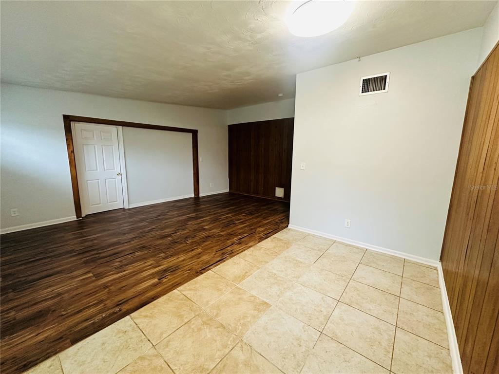 An interior room features a transition from tiled flooring to wood-look laminate flooring — 6033 BALBOA DRIVE, ORLANDO, FL