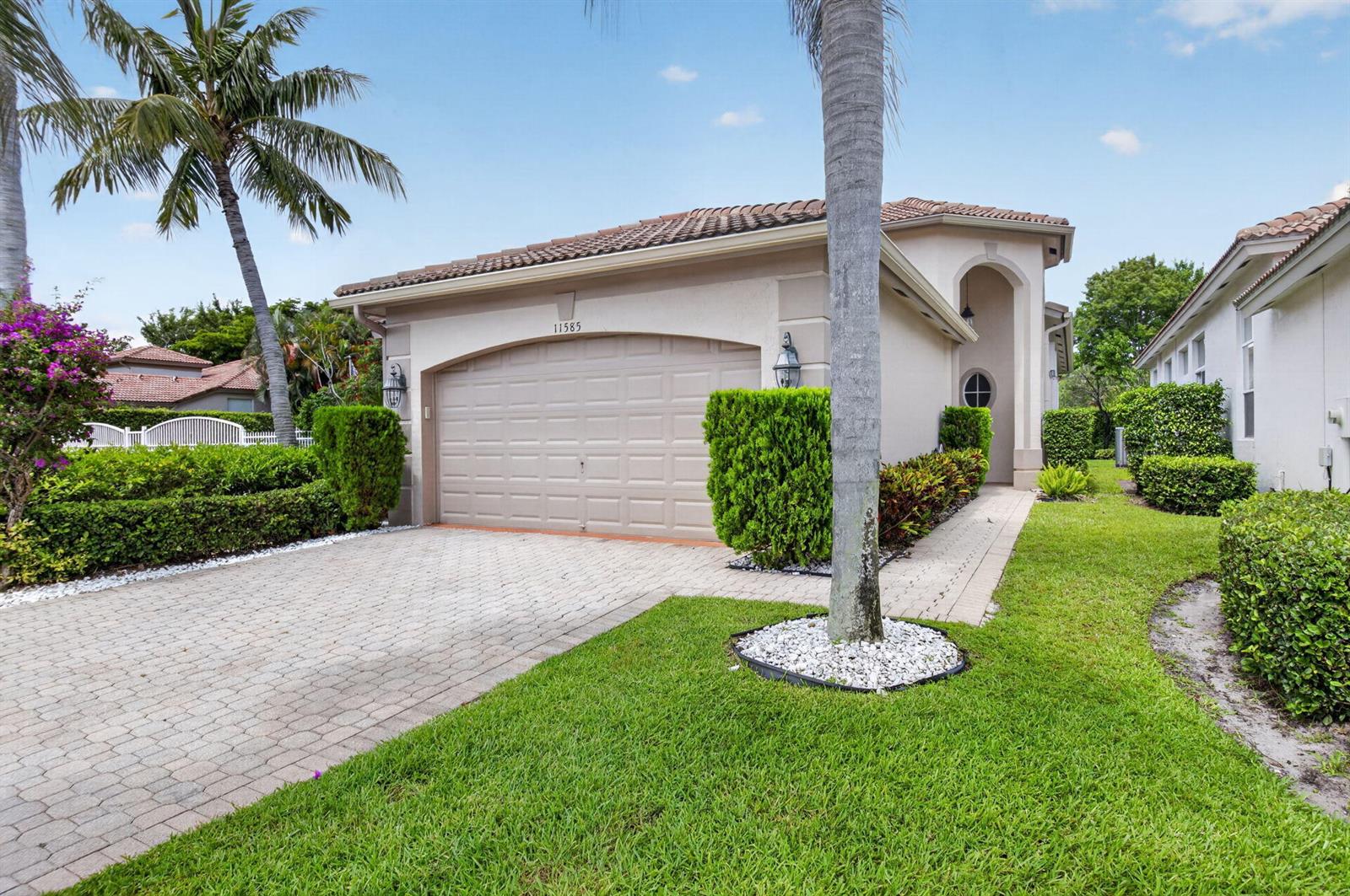 A single-story house with a beige stucco exterior, a two-car garage, and a paved driveway — 11585 Green Golf Lane, Boynton Beach FL 33437, BOYNTON BEACH, FL