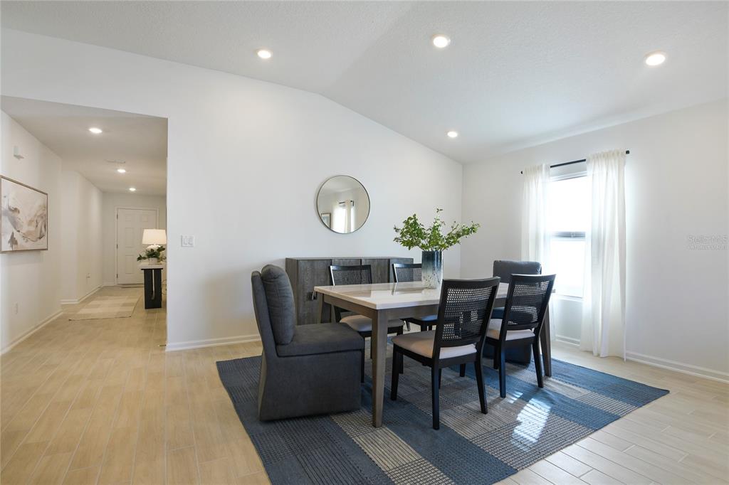 A dining room features a table with six chairs, a sideboard, and a blue rug — 3445 GOLDEN EYE DRIVE, ORANGE PARK, FL