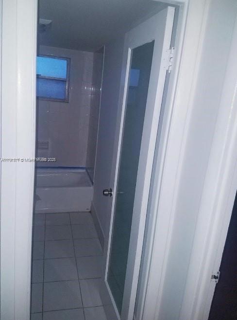 A bathroom with white floor tiles, a white bathtub, and a door with a frosted glass panel — 15600 NW 7th Ave # 319, Miami FL 33169, MIAMI, FL