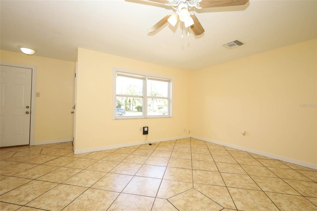 An empty room with light yellow walls, beige tile flooring, and a ceiling fan — 586 TULANE DRIVE, ALTAMONTE SPRINGS, FL