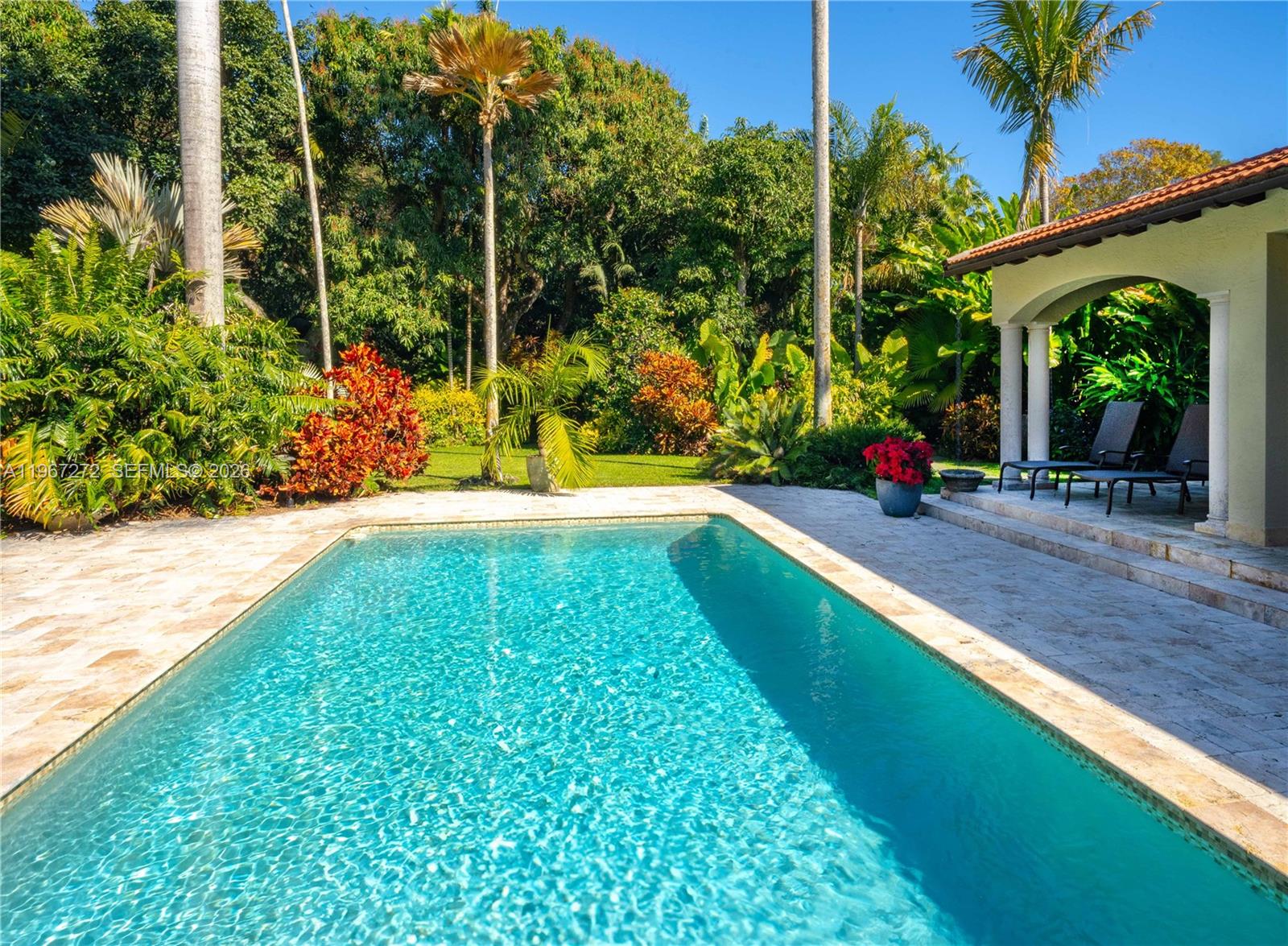 A rectangular swimming pool sits on a stone patio next to a covered porch — 4867 SW 82nd St, Miami FL 33143, MIAMI, FL