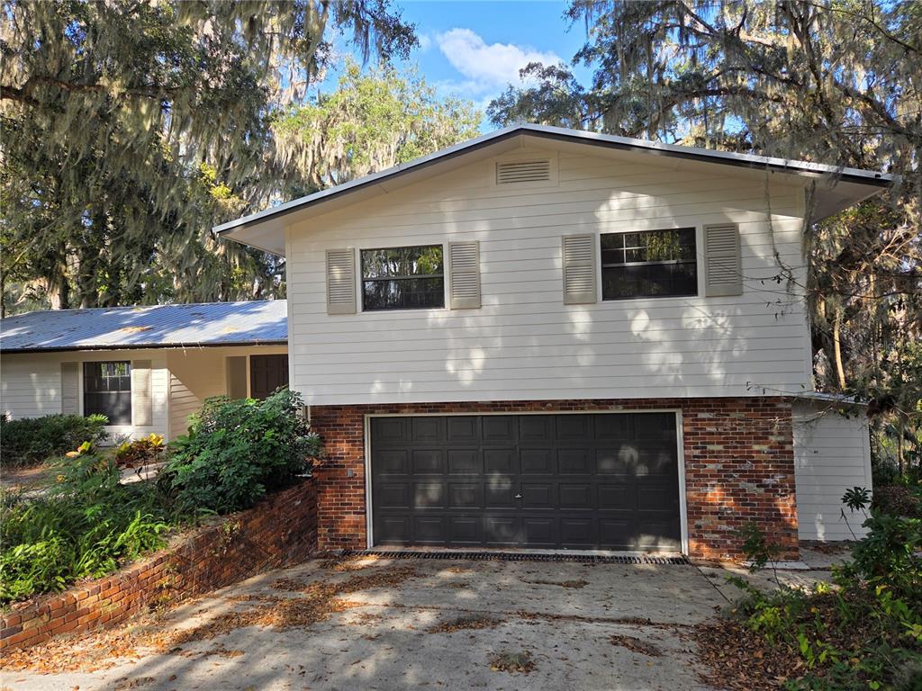 A two-story house with white siding, a brick lower level, and a two-car garage — 2901 SW 4TH COURT, GAINESVILLE, FL