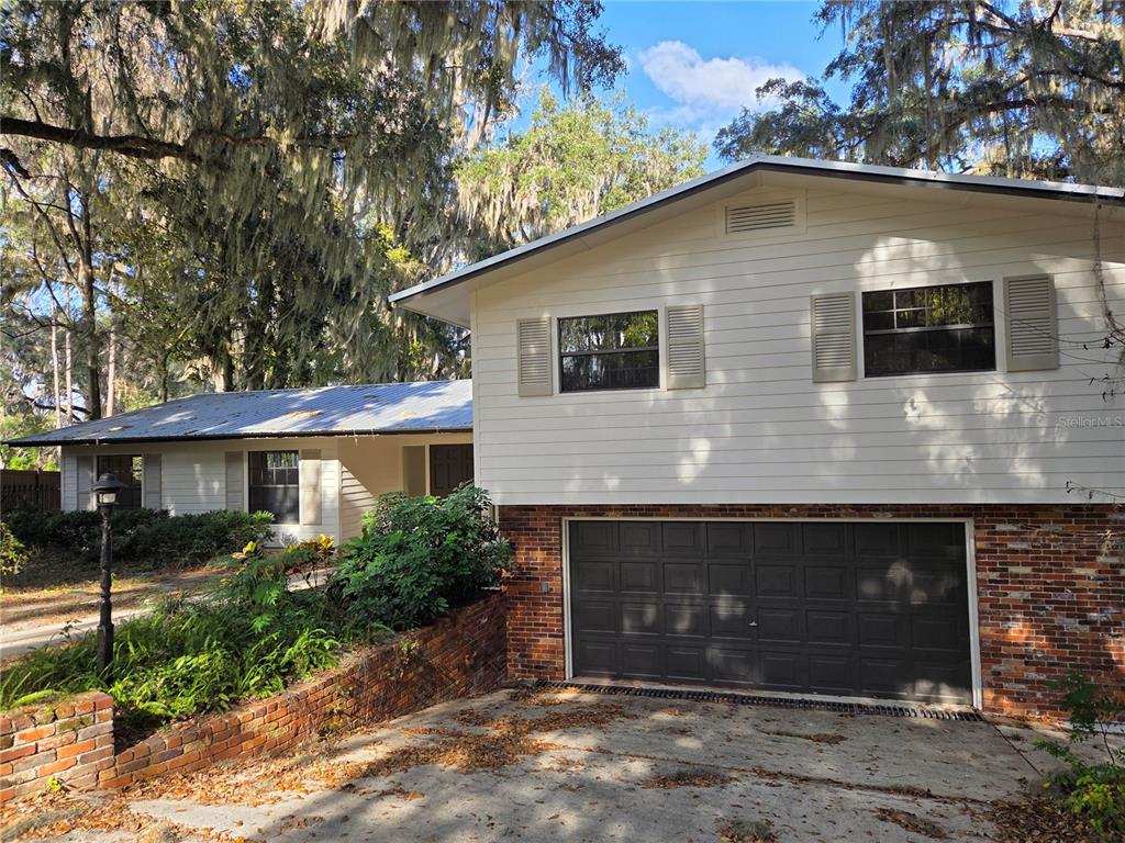 A two-story house with white siding, a brick lower level, and a two-car garage — 2901 SW 4TH COURT, GAINESVILLE, FL