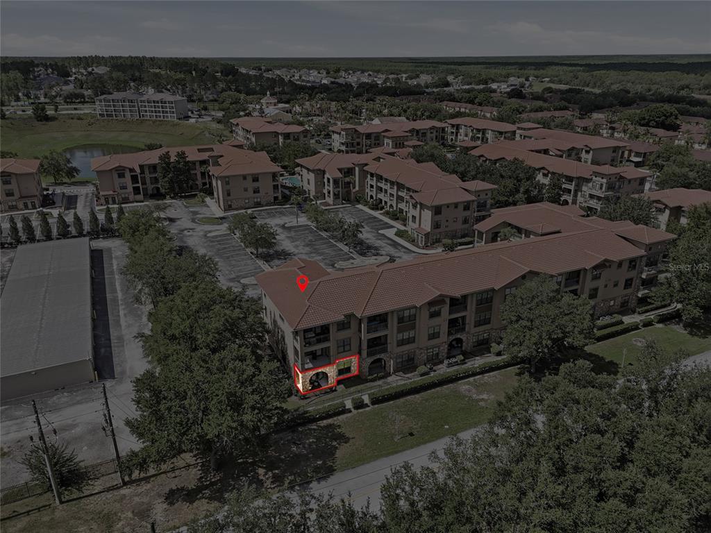 An aerial view shows a multi-story apartment building with a highlighted ground-floor unit — 901 CHARO PARKWAY UNIT 717, DAVENPORT, FL