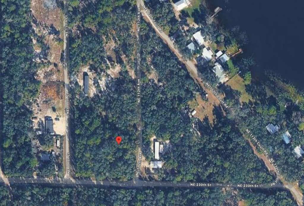 This is an aerial map view of a wooded residential lot with a red location marker — NO SITUS, FORT MC COY, FL