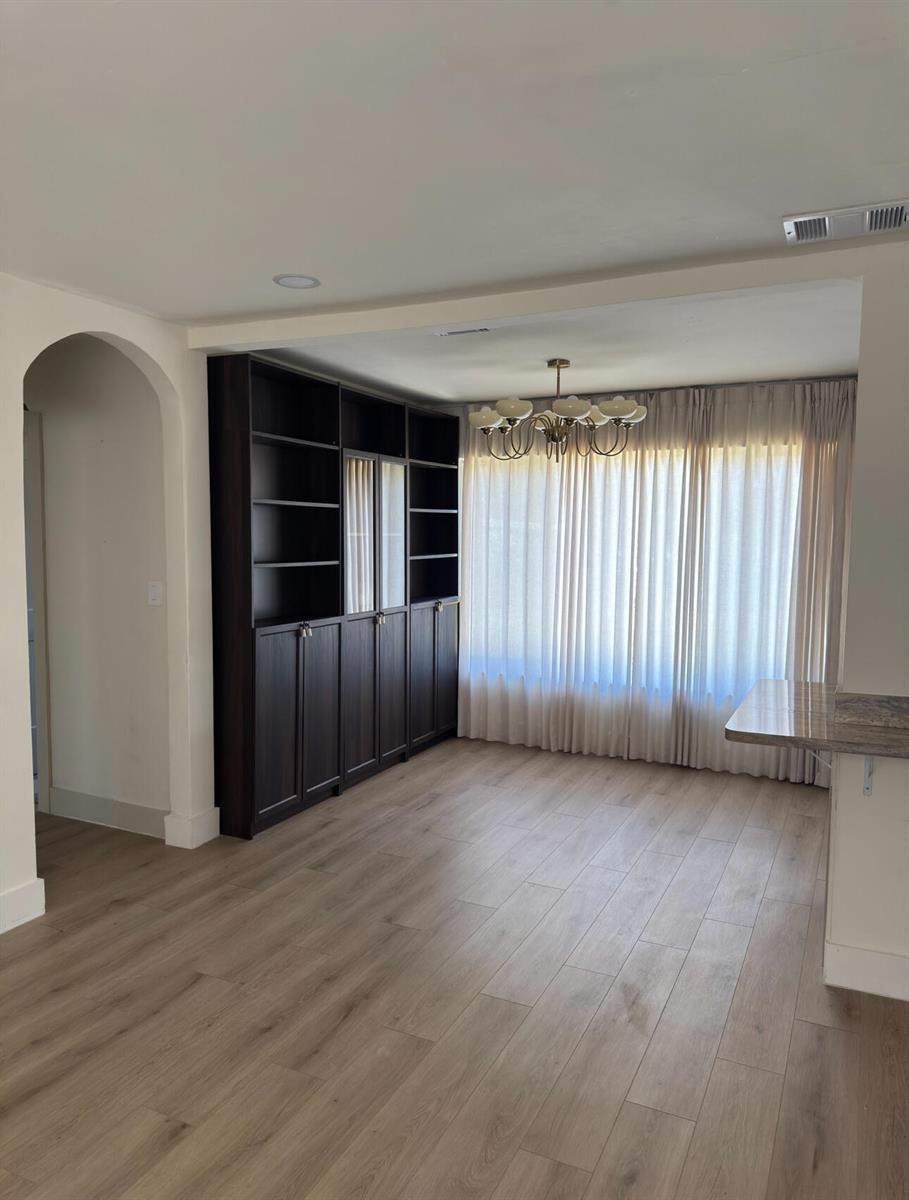 A dining room features light wood-look flooring, a dark built-in cabinet, and floor-to-ceiling curtains — 2648 Washington Street, Hollywood FL 33020, HOLLYWOOD, FL