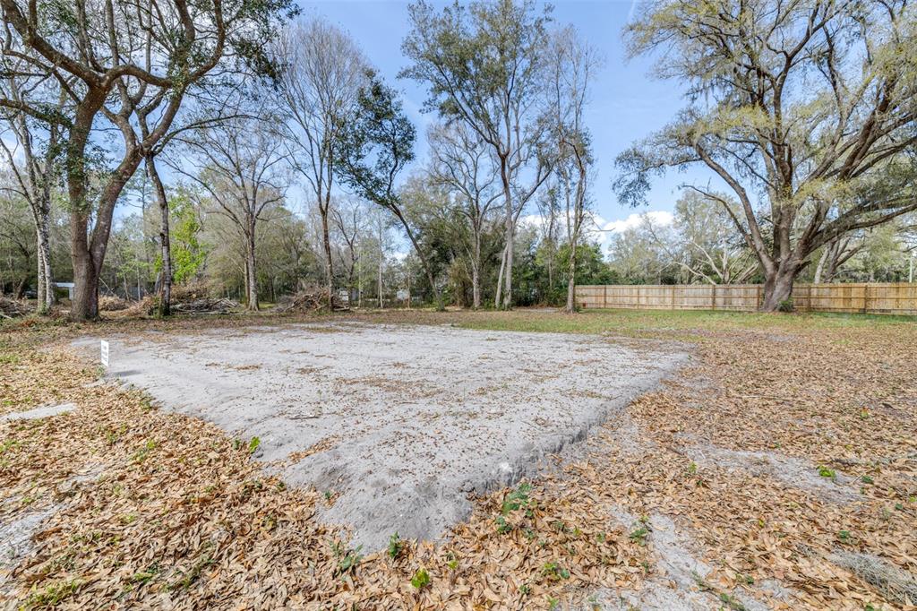 A cleared, sandy rectangular lot is surrounded by mature trees and a wooden fence — SE 124TH AVENUE, WEBSTER, FL