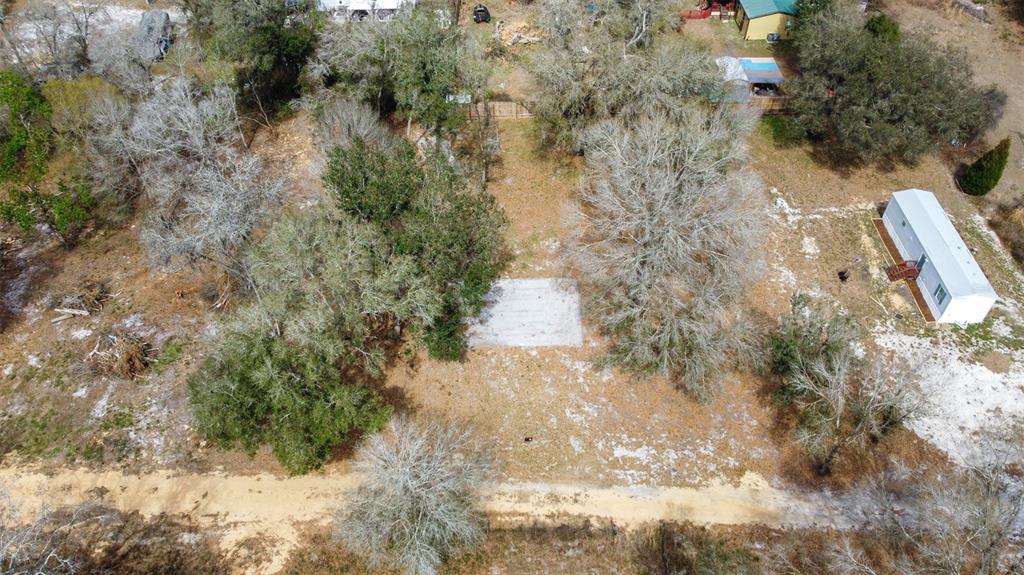 An aerial view shows a wooded lot with a concrete slab and a mobile home — SE 124TH AVENUE, WEBSTER, FL