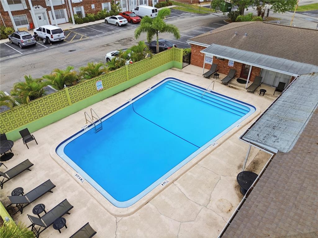 An aerial view of a rectangular swimming pool surrounded by a patio and lounge chairs — 4507 9TH STREET W. UNIT I3, BRADENTON, FL