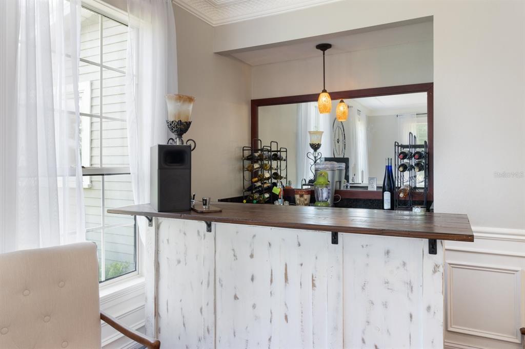 A rustic white wooden bar with a dark wood countertop sits in a dining room — 2065 SW 37TH STREET ROAD, OCALA, FL