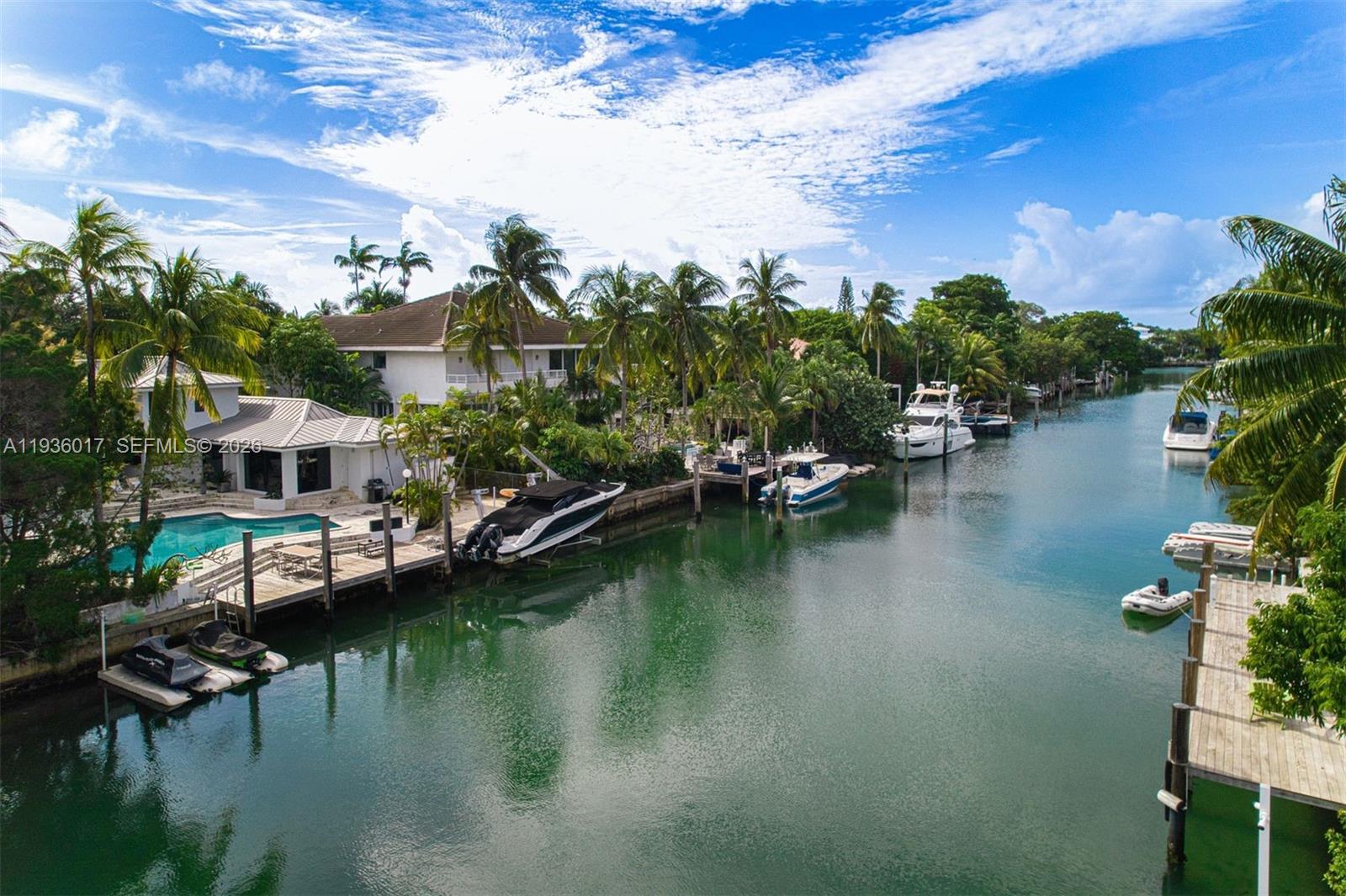 An aerial view shows a waterfront house with a pool, dock, and several moored boats — 121 Knollwood Drive, Key Biscayne FL 33149, KEY BISCAYNE, FL