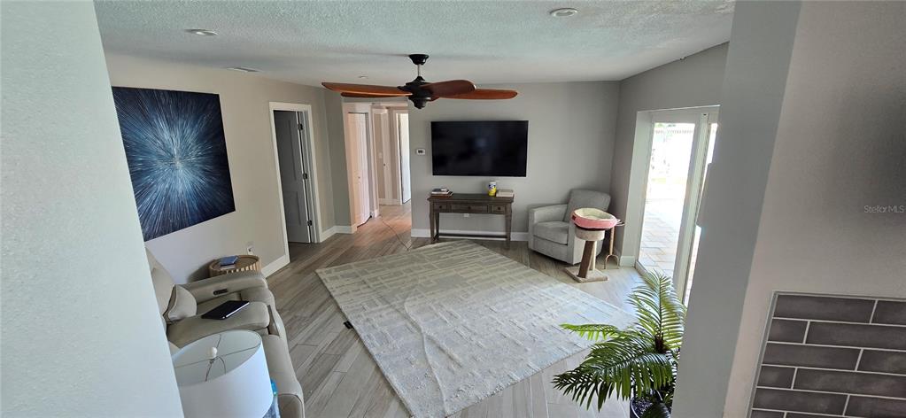 A living room features light tile flooring, a beige sectional sofa, and a glass-paneled front door — 6351 3RD PALM POINT, ST PETE BEACH, FL