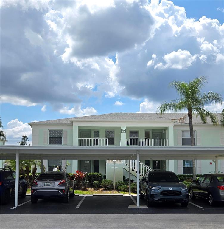 A two-story apartment building with a covered parking area and several parked cars — 5725 GREENWOOD AVENUE UNIT 5201, NORTH PORT, FL