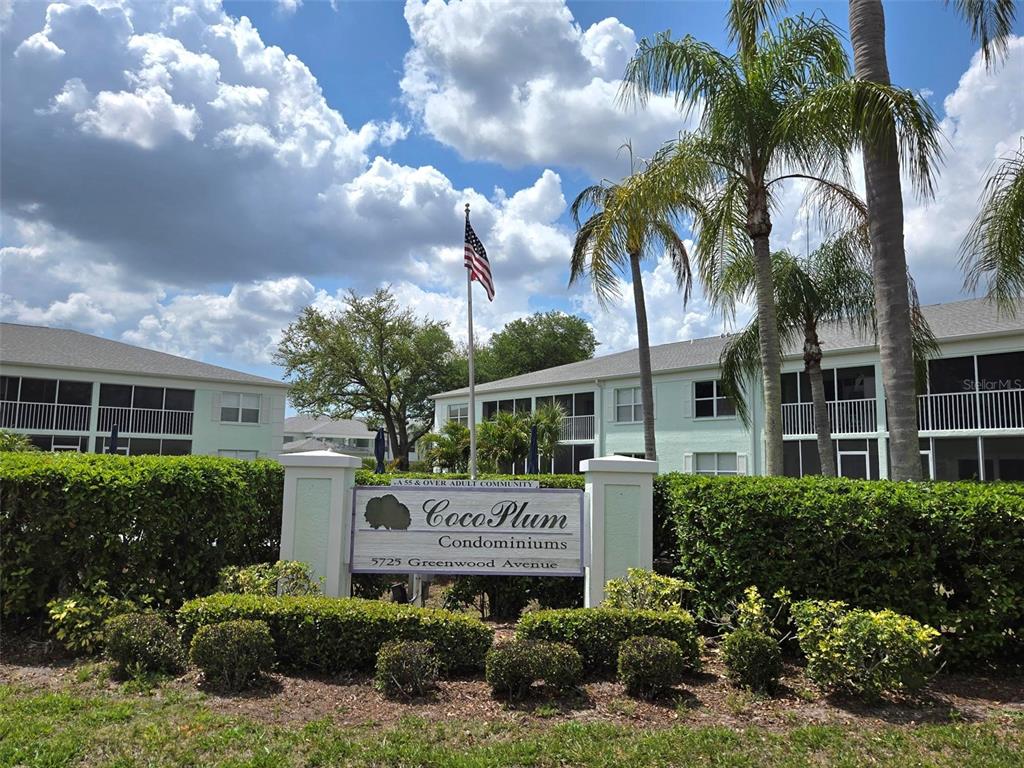 A sign for Coco Plum Condominiums stands in front of multi-story buildings and palm trees — 5725 GREENWOOD AVENUE UNIT 5201, NORTH PORT, FL