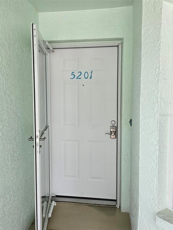 A white front door with the number 5201 and a keypad lock stands open — 5725 GREENWOOD AVENUE UNIT 5201, NORTH PORT, FL