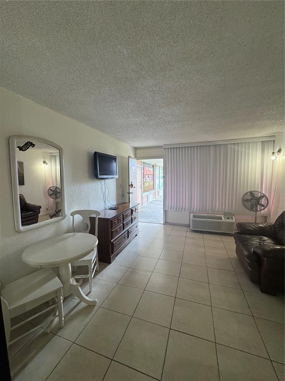 A living room features tiled floors, a small dining table, a dresser, and a leather sofa — 43420 HIGHWAY 27 UNIT 340, DAVENPORT, FL