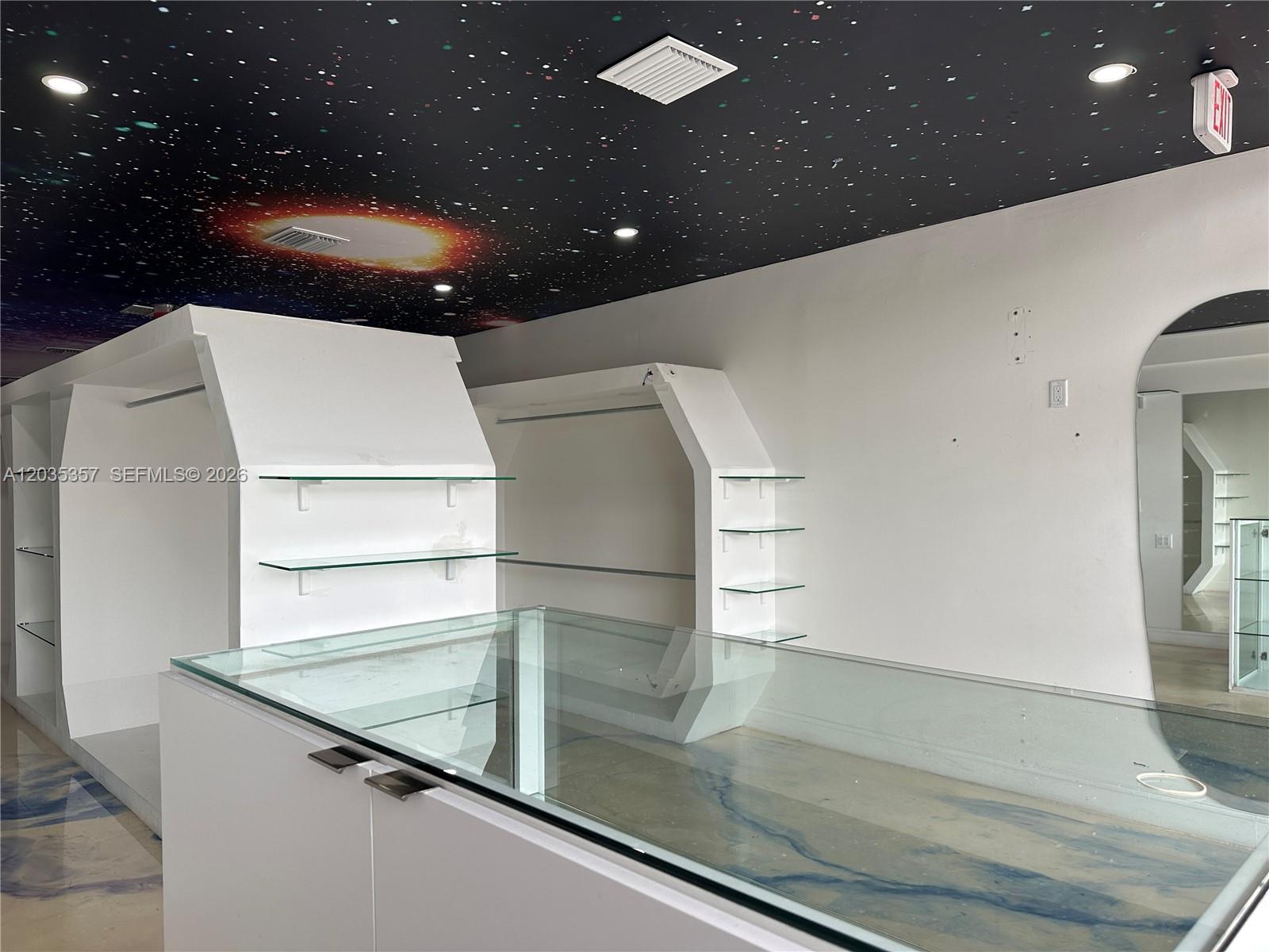 A retail space features white display shelving, a glass counter, and a galaxy-themed ceiling — 142 Hialeah Dr, Hialeah FL 33010, HIALEAH, FL