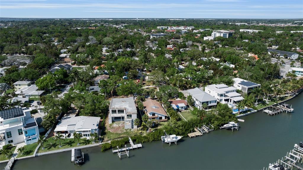 An aerial view shows waterfront homes, including one under construction, along a canal — 1040 SYLVAN DRIVE, SARASOTA, FL