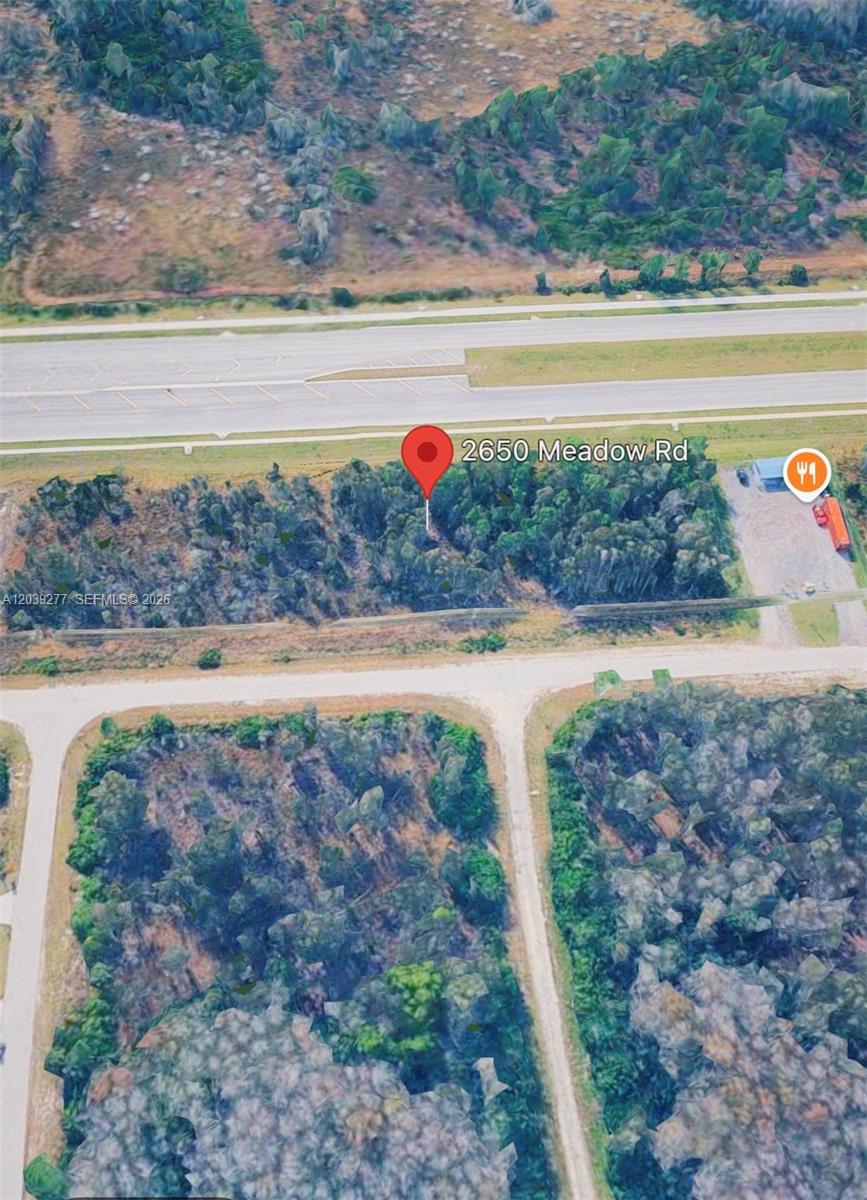 This is an aerial map view of a wooded lot located next to a highway — 2650 Meadow RD, Lehigh Acres FL 33974, LEHIGH ACRES, FL