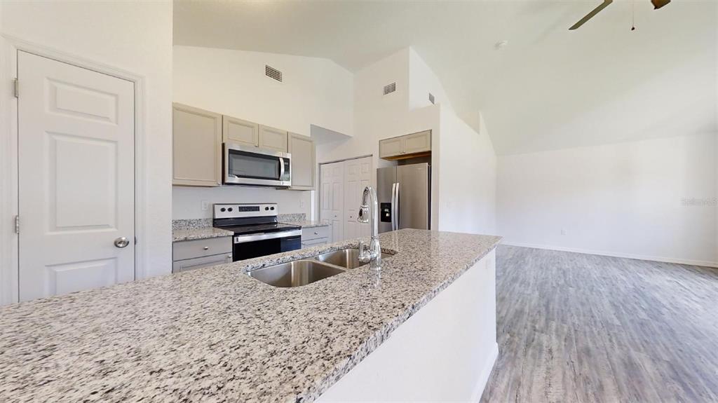 A kitchen with granite countertops, stainless steel appliances, and light wood cabinetry — 13730 SW 111TH STREET, DUNNELLON, FL