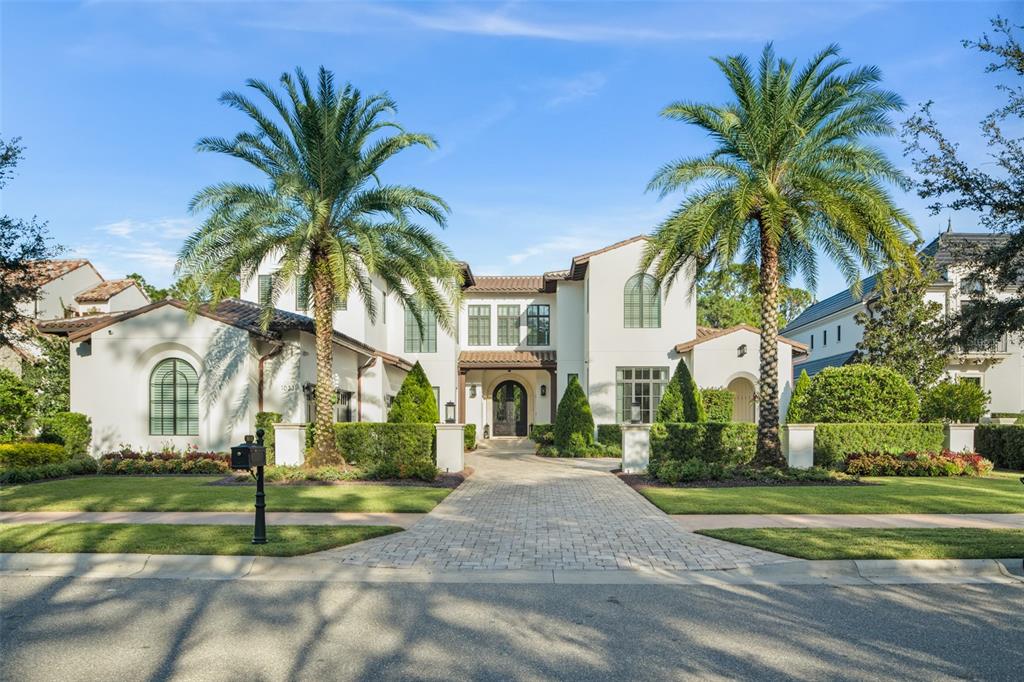 A two-story white stucco house with a tiled roof, palm trees, and a paved driveway — 10331 LOS FELIZ DRIVE, ORLANDO, FL